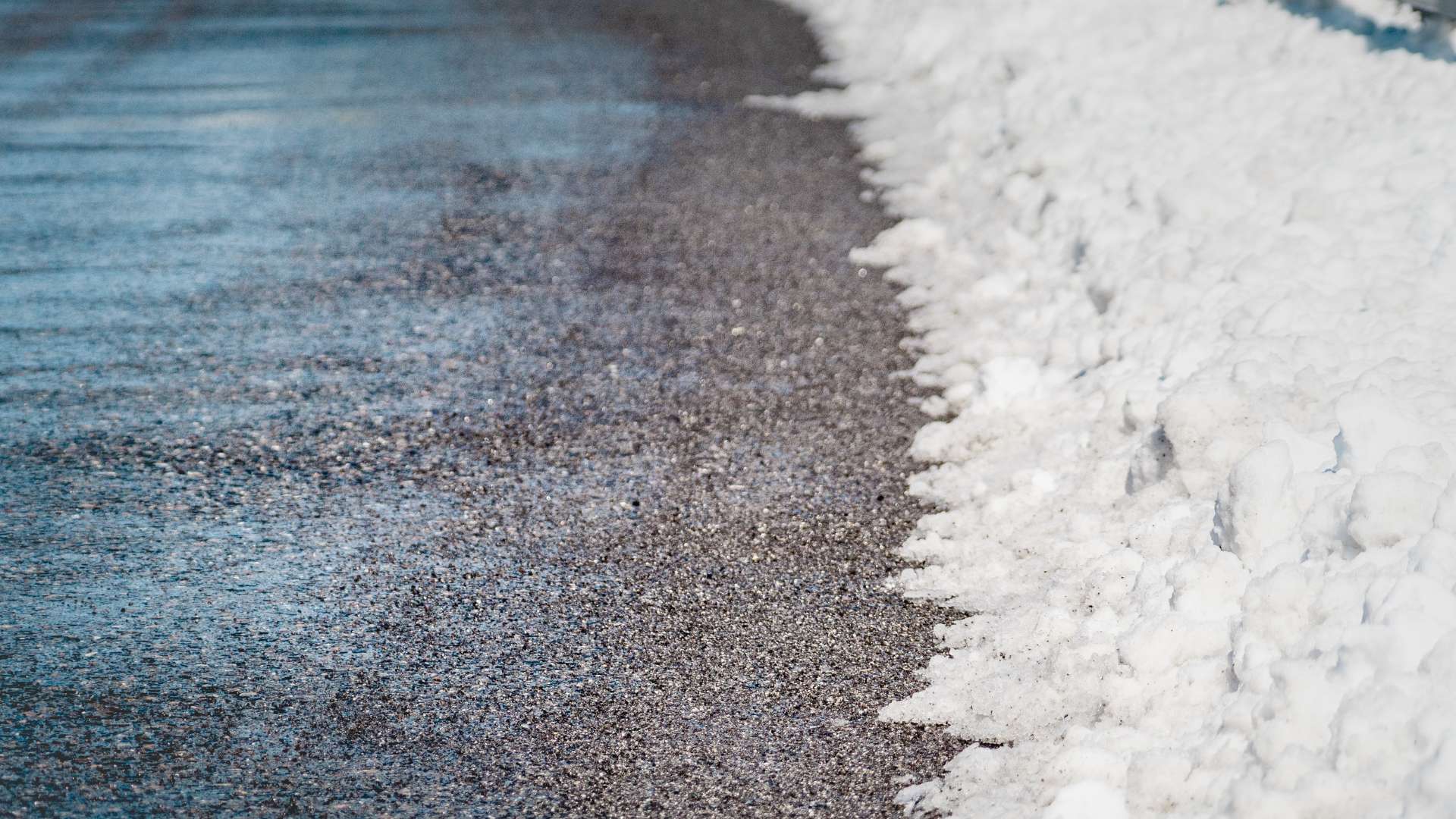 Snow melting along driveway edge maintained by Hill Landscaping in Clinton Township